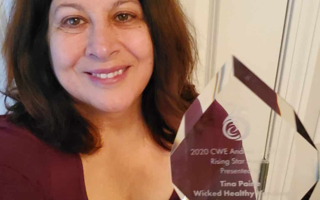 Tina Paine holding an award she won