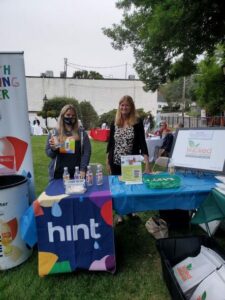 Two women at a booth at a park event