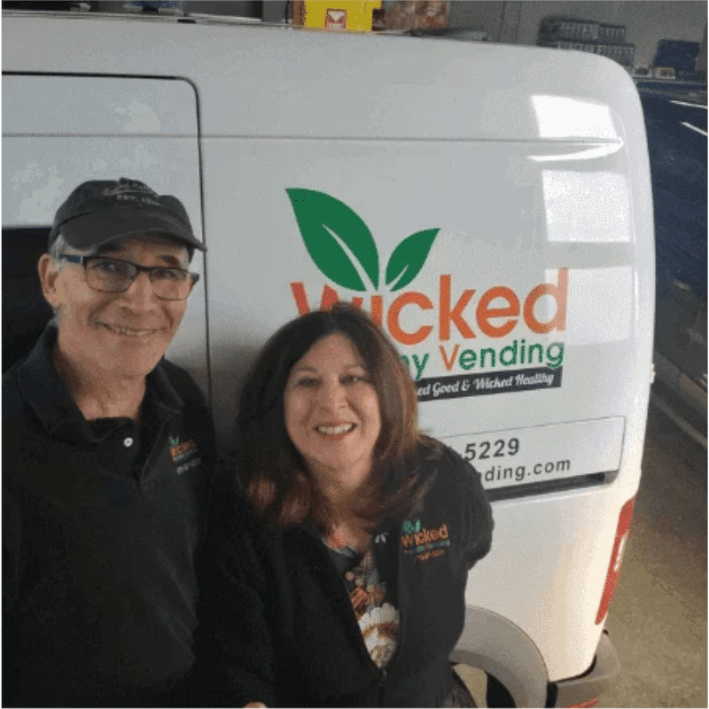 Tina and John Paine standing in front of a Wicked Healthy Vending van.