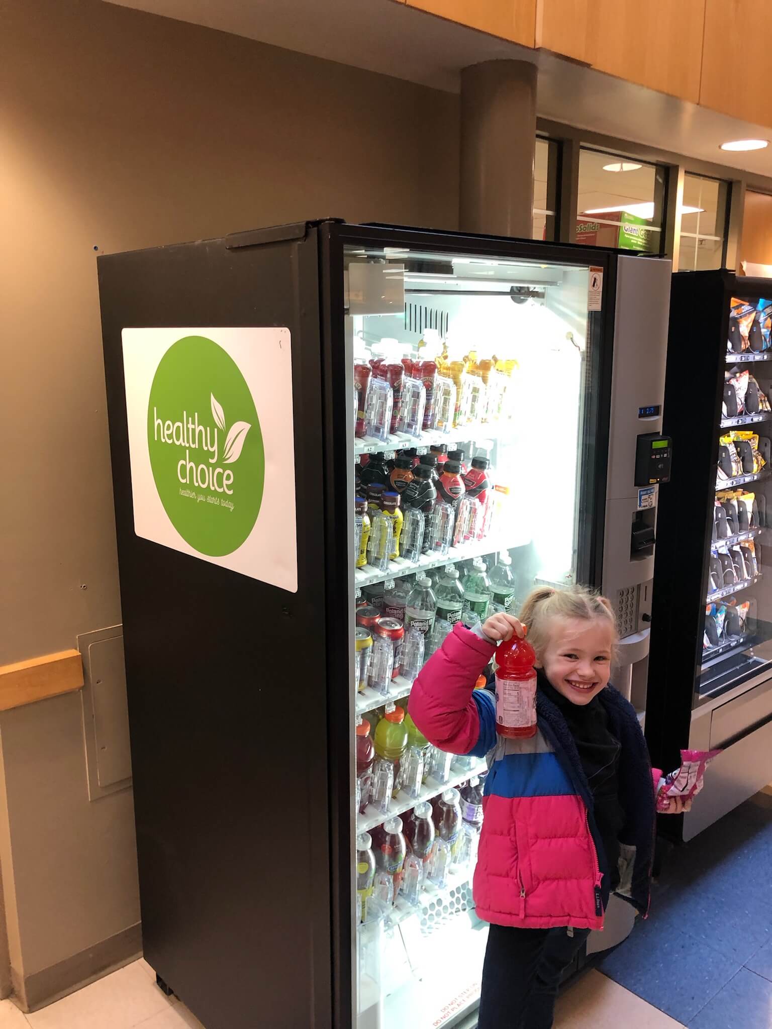 A young girl getting a healthy drink from a wicked healthy vending machine